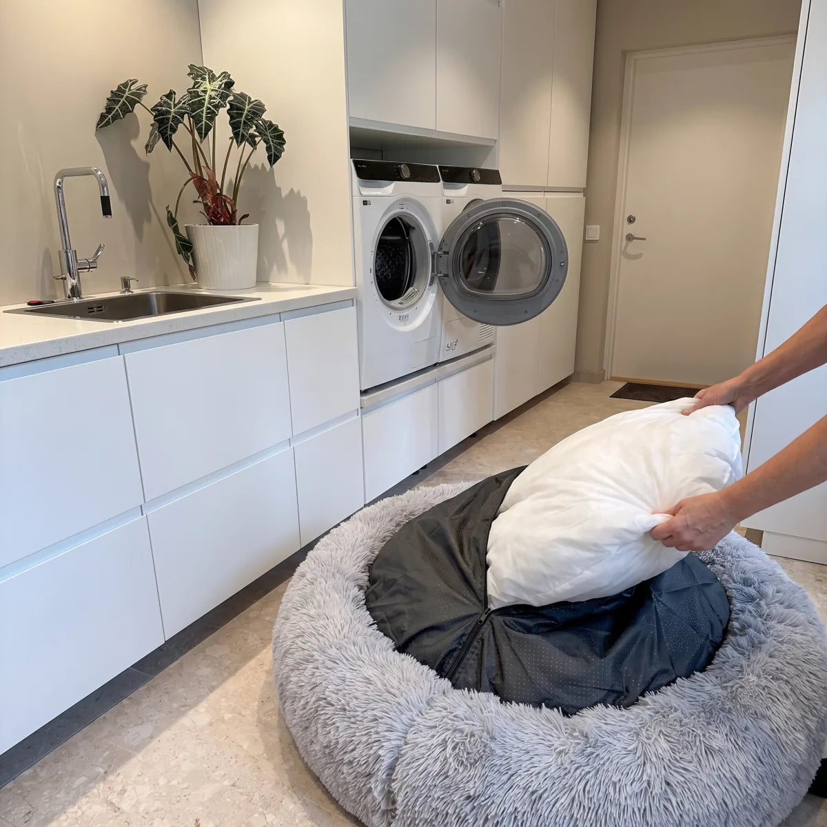 Innerdelen lyfts ur bädden framför den öppna torktumlaren