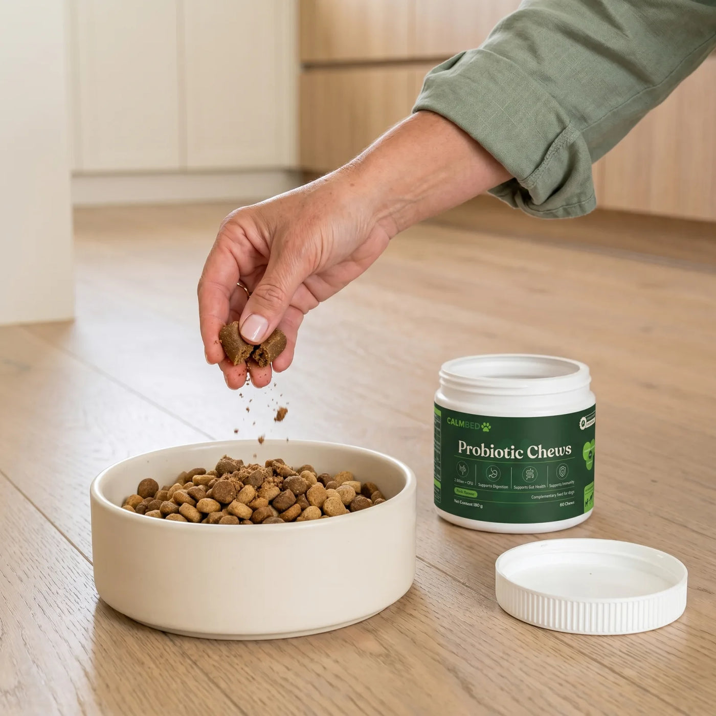 Hand sprinkling chews into a dog bowl